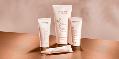 Pevonia's ProCorrective products alongside one another on a reflective brown table, in front of a beige backdrop.