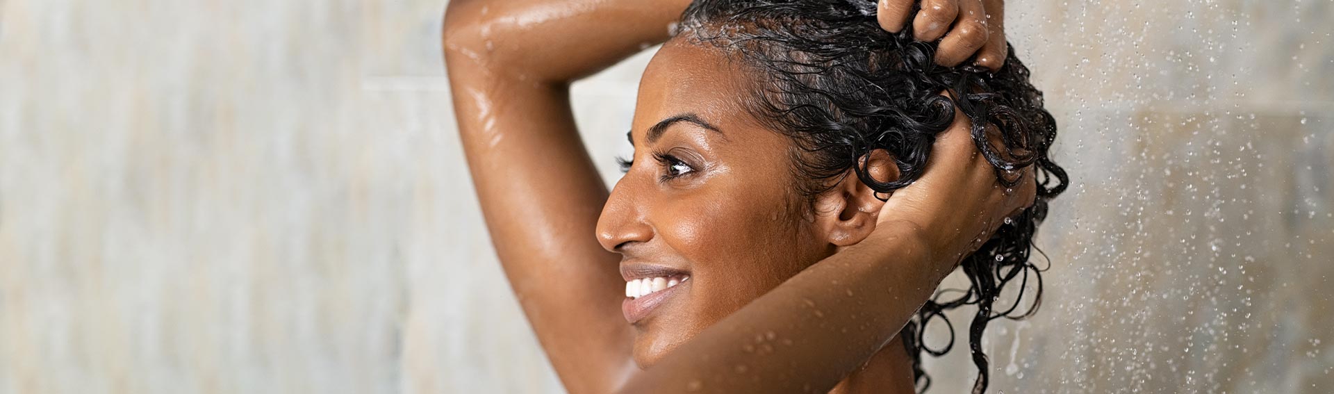 A woman washing her hair in the shower.