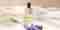 Pevonia's De-Stress Escape Aromatic Oil with Lavender stems lying in front.